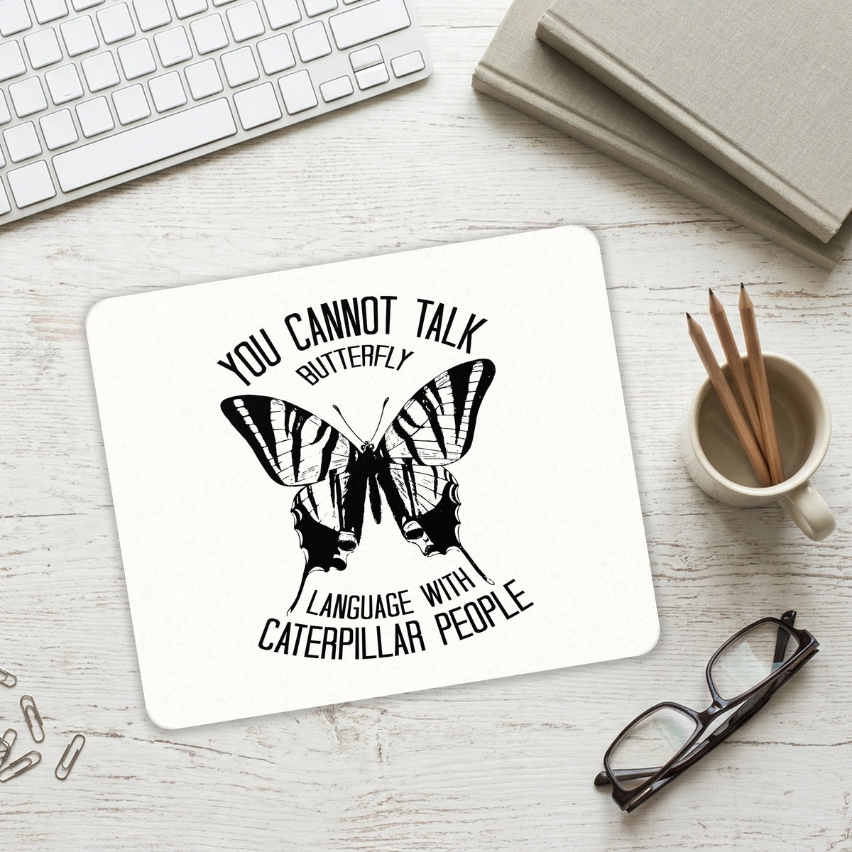 Can't Talk Butterfly with Caterpillar People mouse pad on a desk with a keyboard