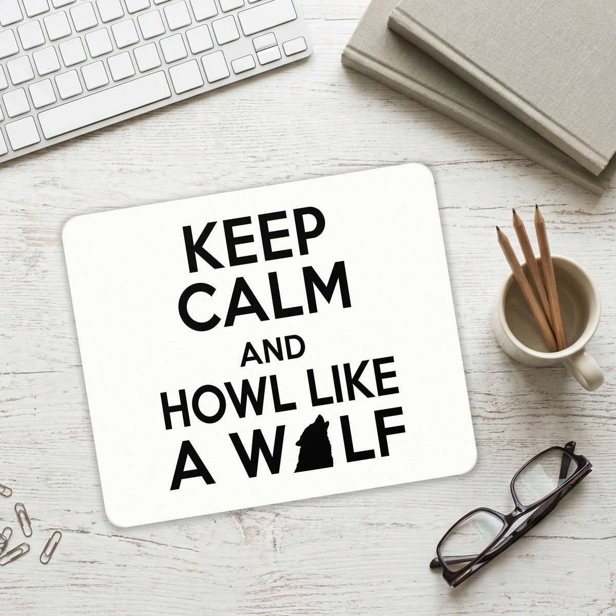 Keep Calm Howl Like a Wolf mouse pad on a desk with a keyboard