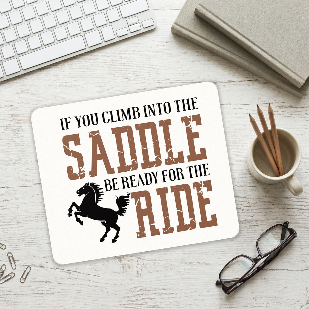 Climb into the Saddle, Ready for a Ride mouse pad on a desk with a keyboard