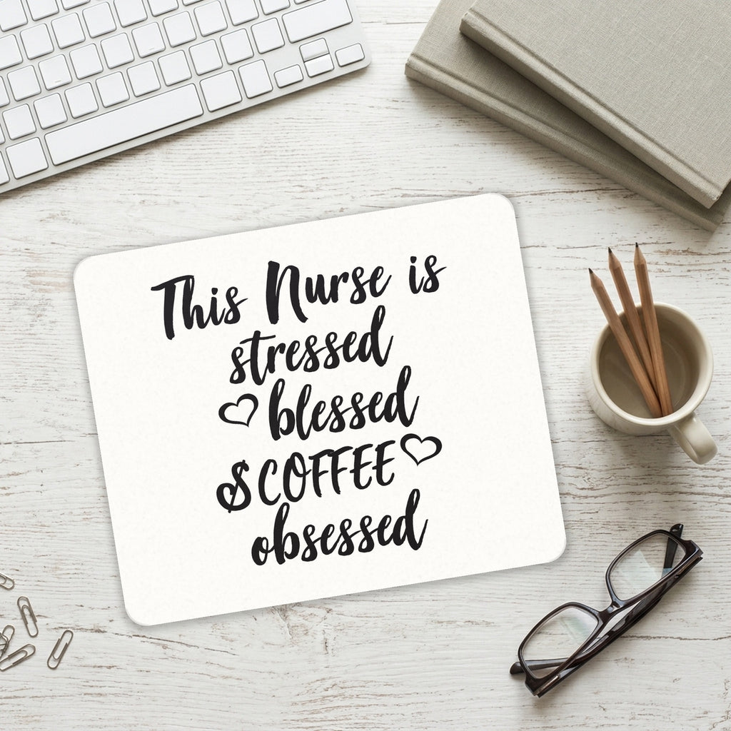 This Nurse Is Stressed Blessed & Coffee Obsessed mouse pad on a desk with a keyboard