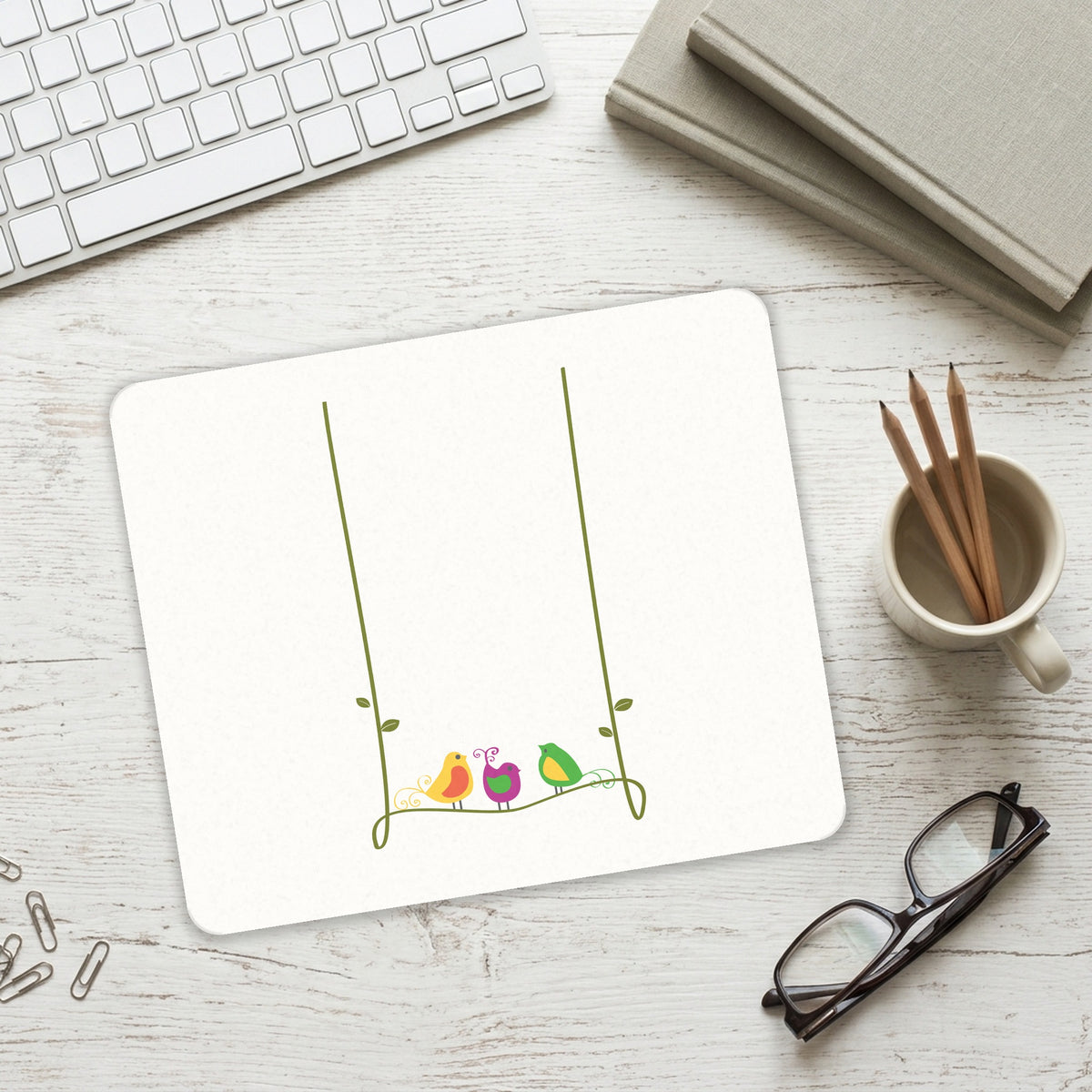Colorful Birds Cartoon on a Vine mouse pad on a desk with a keyboard