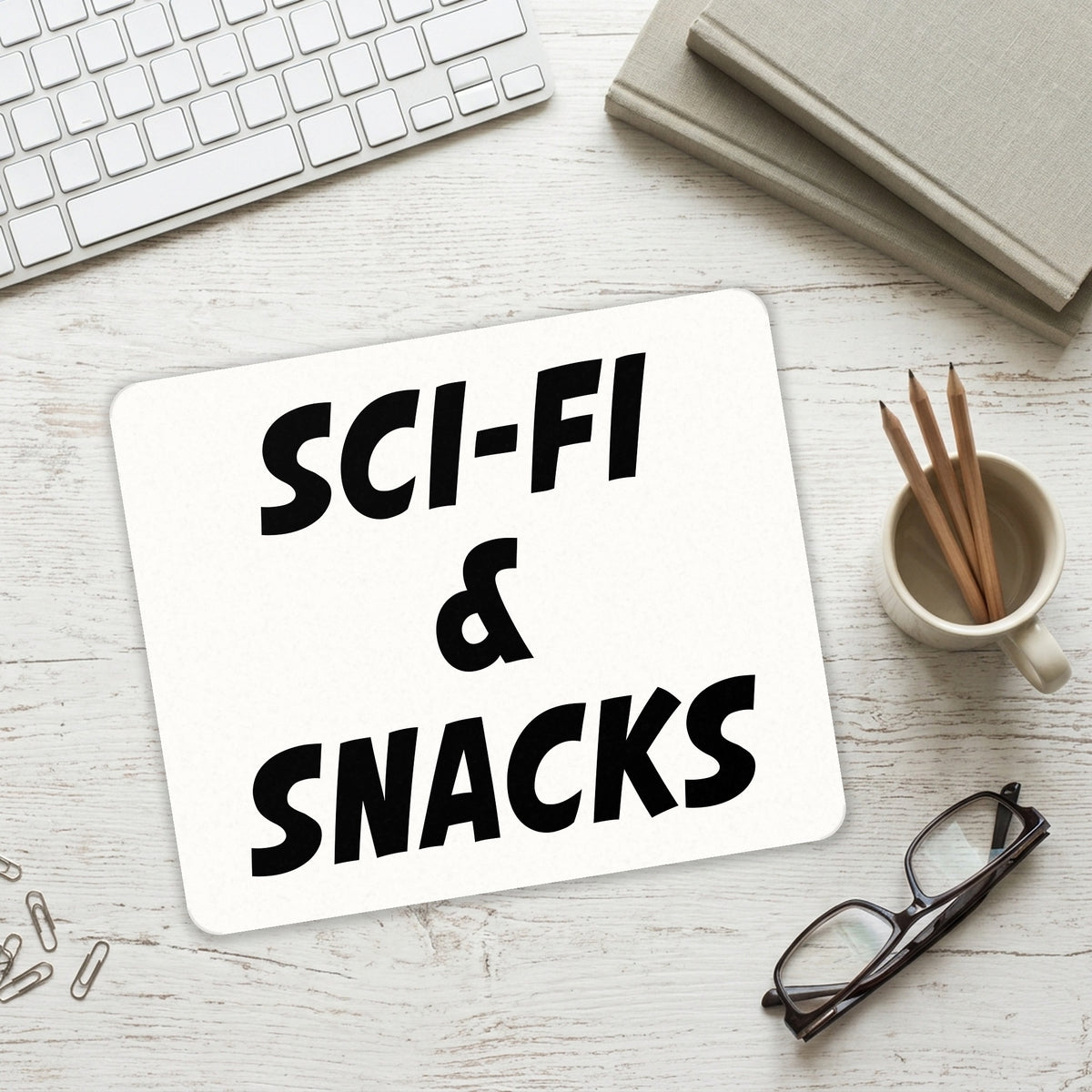 Sci-Fi & Snacks mouse pad on a desk with a keyboard