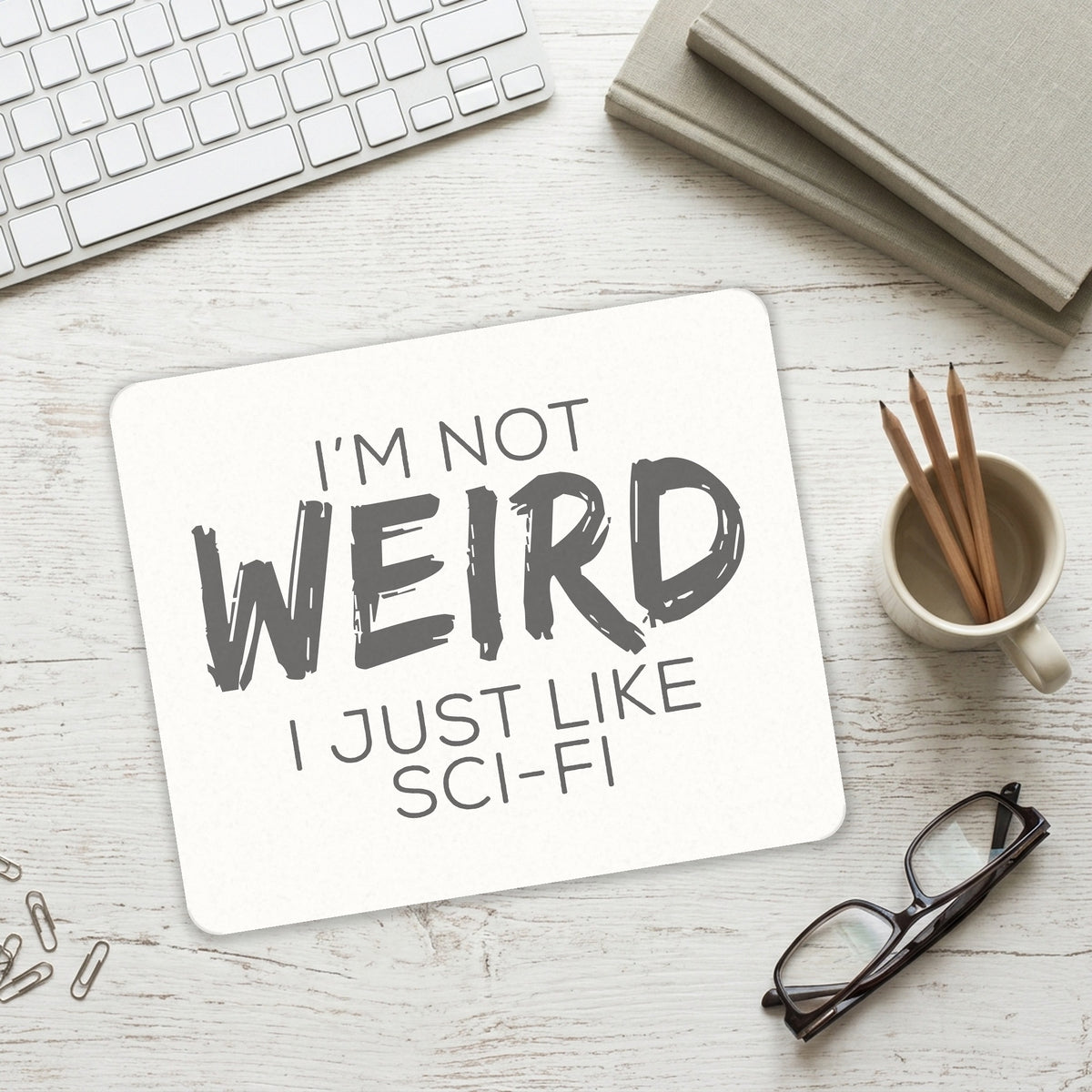 I'm Not Weird, I Just Like Sci-Fi mouse pad on a desk with a keyboard