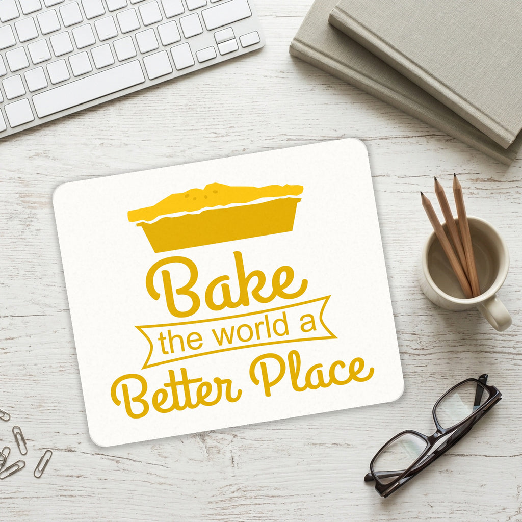 Bake the World a Better Place mouse pad on a desk with a keyboard