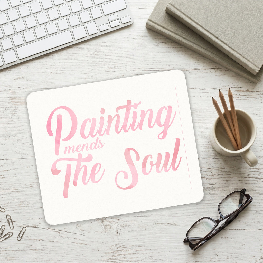Painting Mends the Soul mouse pad on a desk with a keyboard