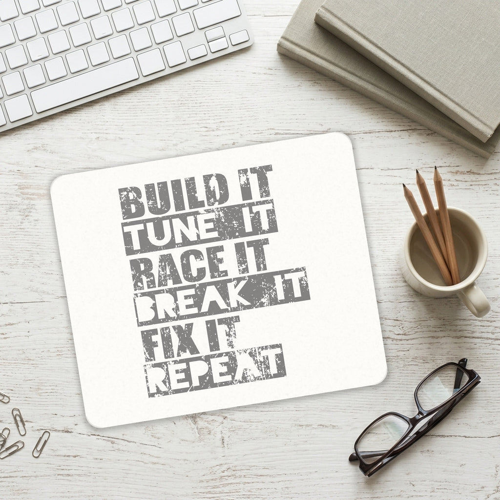 Build It Tune Race Break Fix Repeat mouse pad on a desk with a keyboard