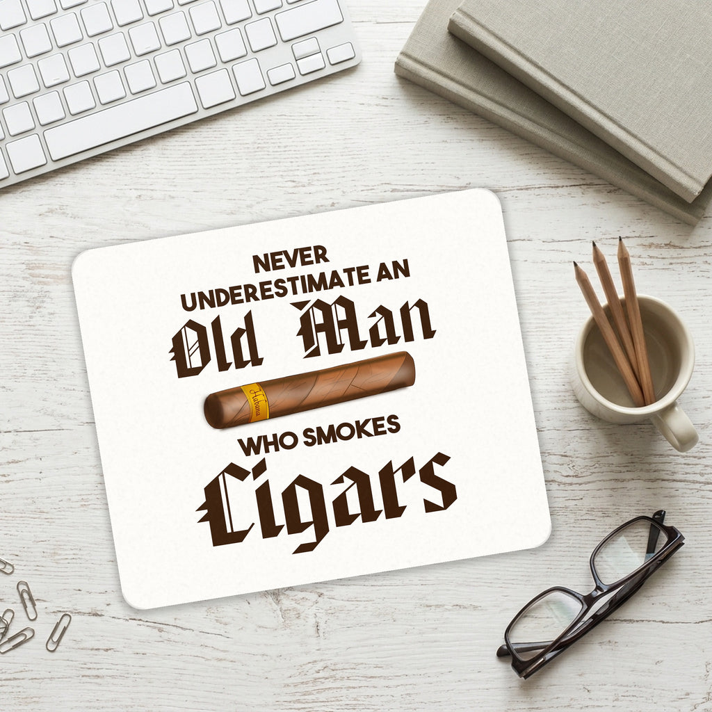 Never Underestimate Old Man Who Smokes Cigars mouse pad on a desk with a keyboard