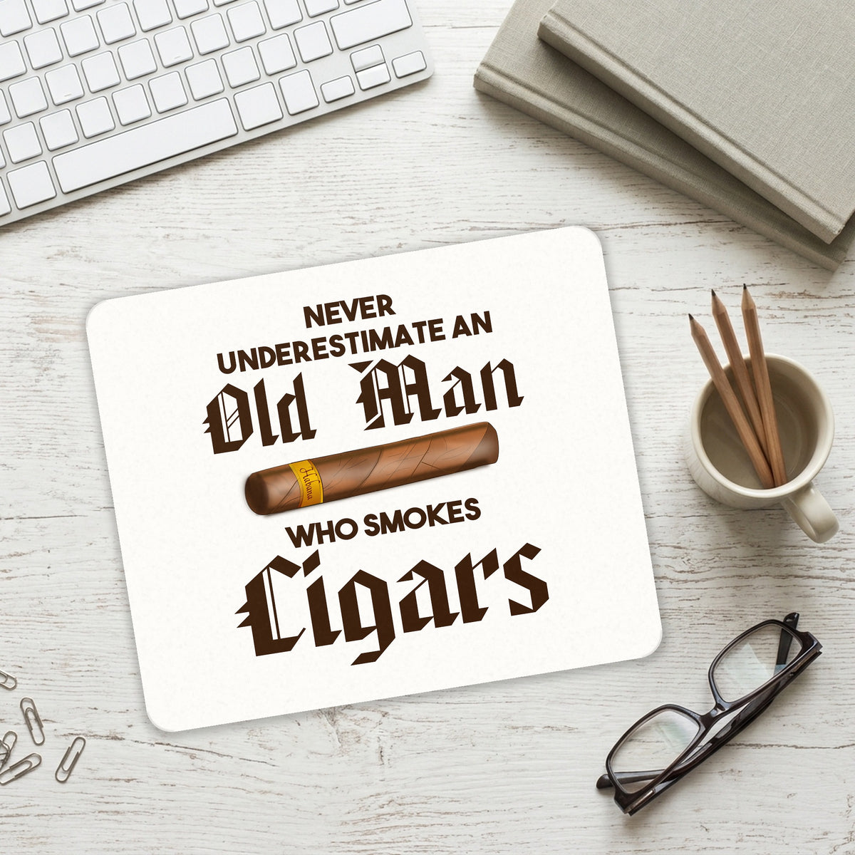 Never Underestimate Old Man Who Smokes Cigars mouse pad on a desk with a keyboard