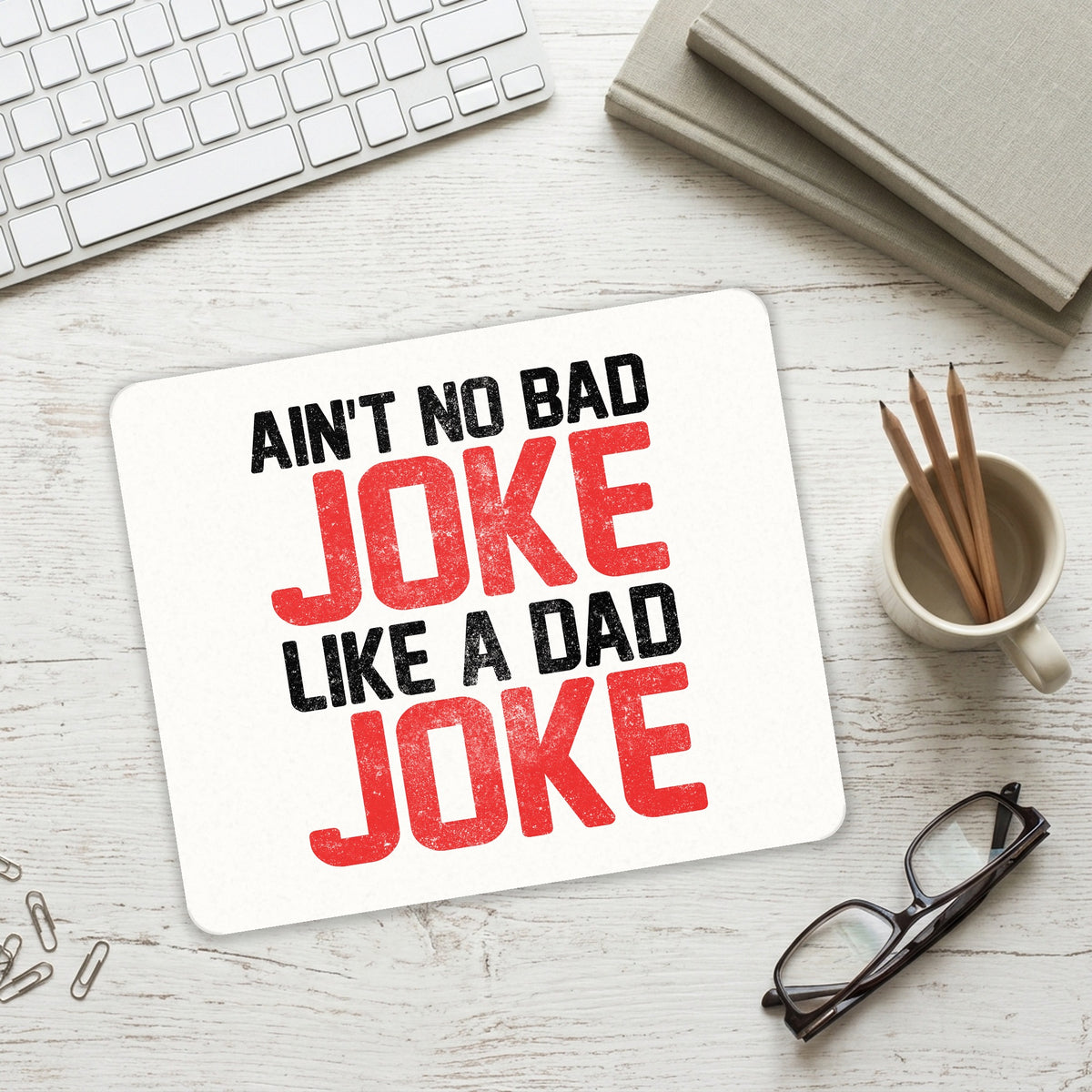 Ain't No Bad Joke Like a Dad Joke mouse pad on a desk with a keyboard