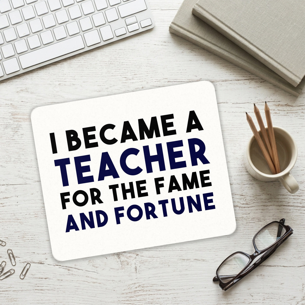 I Became a Teacher for the Fame & Fortune mouse pad on a desk with a keyboard