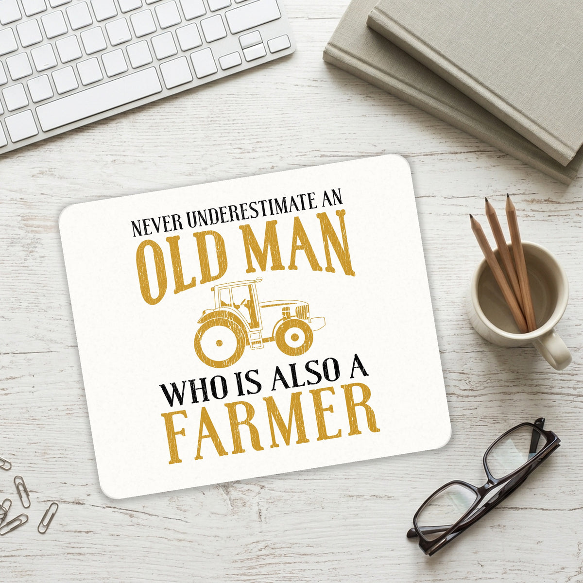 Never Underestimate Old Man Farmer mouse pad on a desk with a keyboard