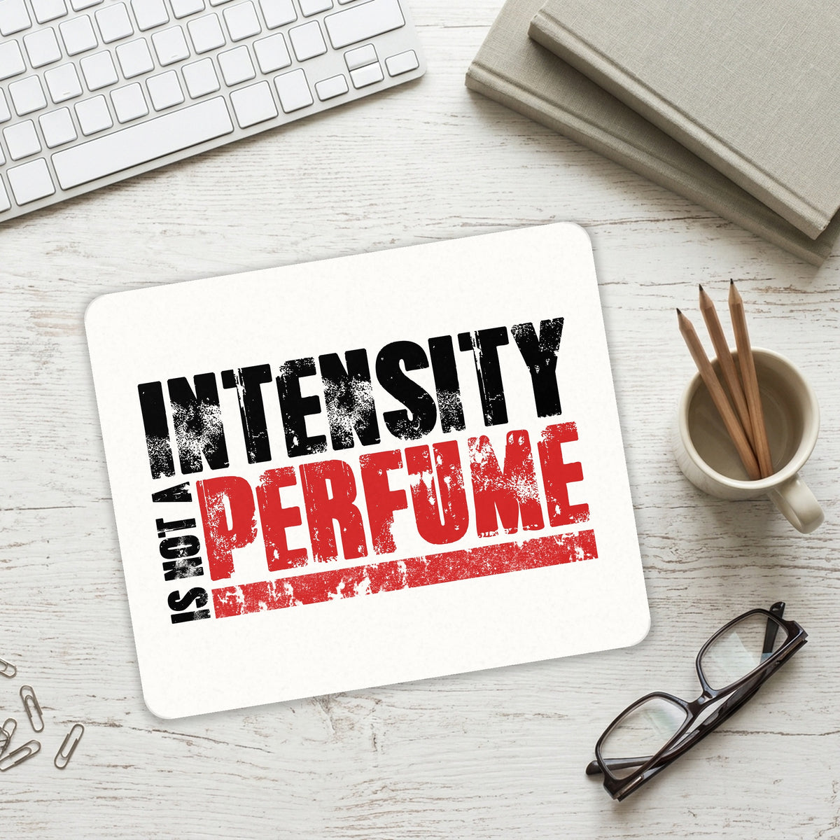 Intensity Isn't A Perfume mouse pad on a desk with a keyboard