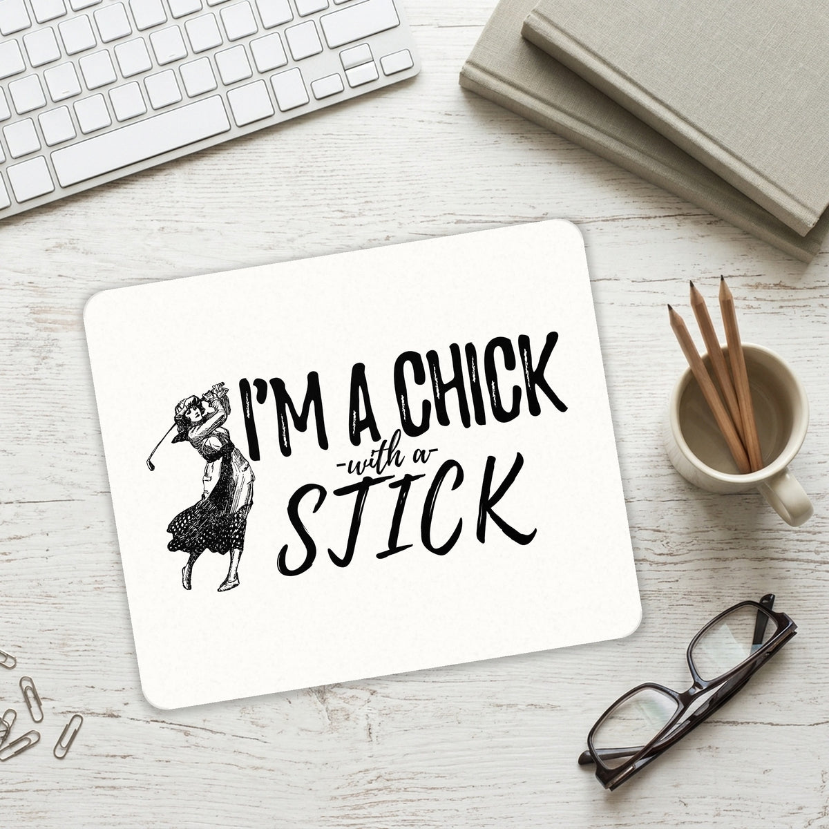 I'm a Chick with a Stick Golf mouse pad on a desk with a keyboard