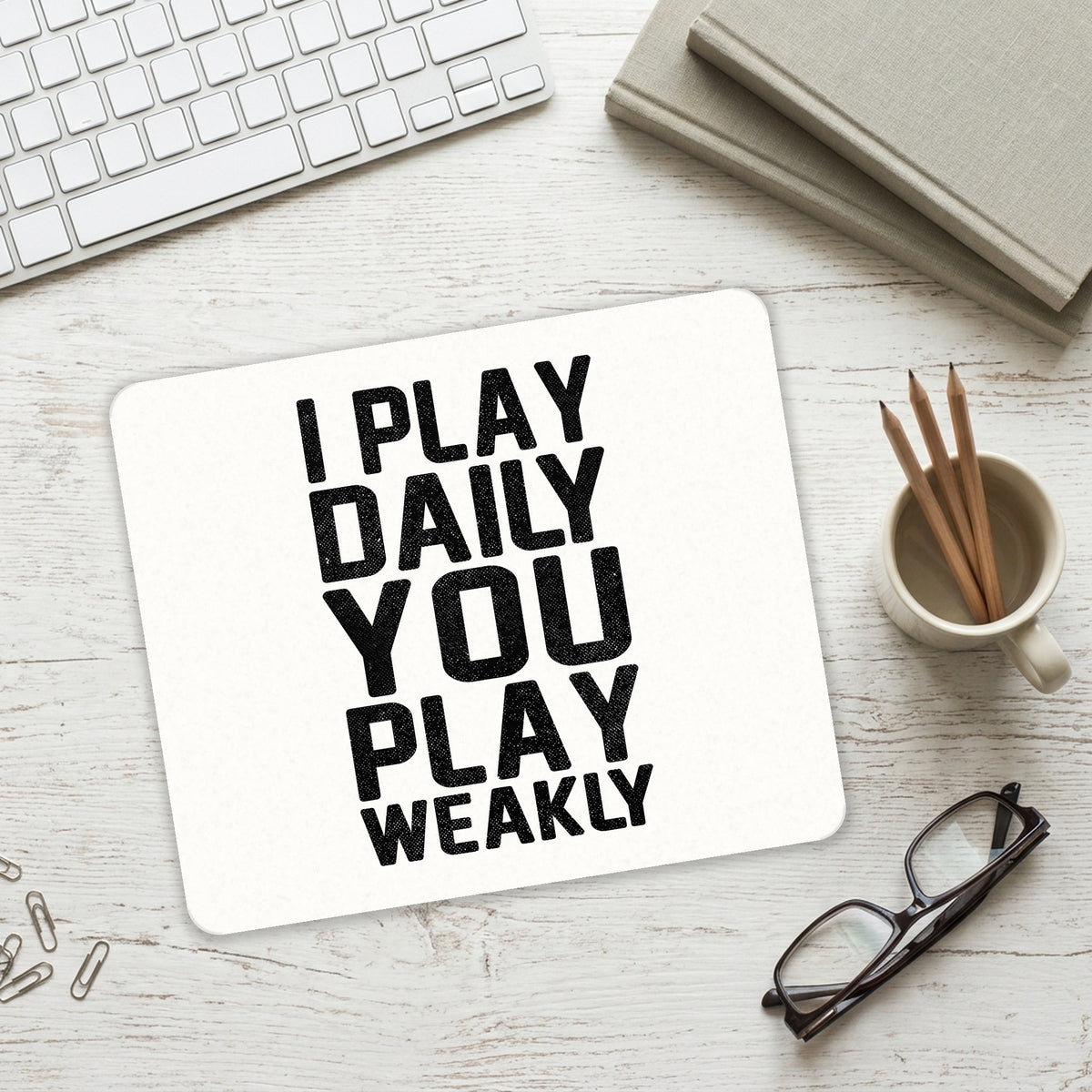 I Play Daily You Play Weakly mouse pad on a desk with a keyboard