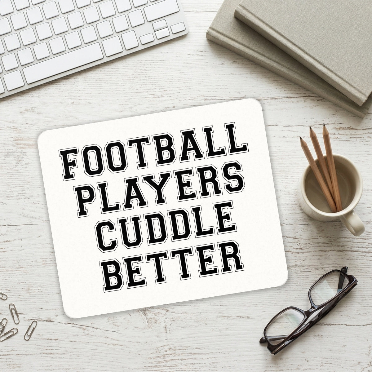 Football Players Cuddle Better mouse pad on a desk with a keyboard