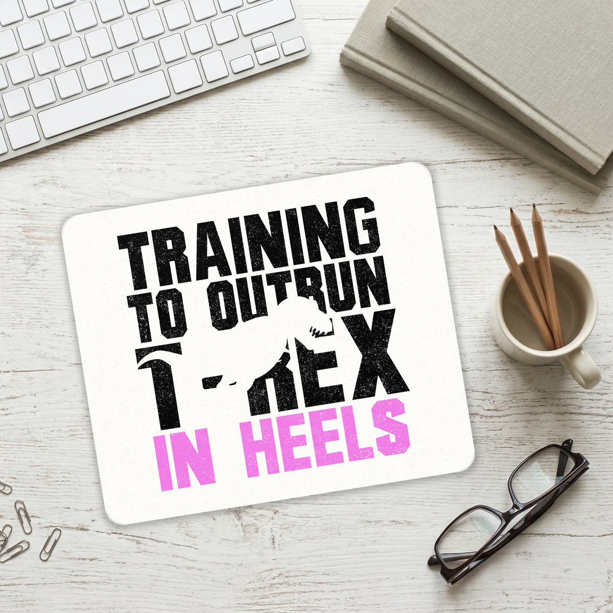 Training to Outrun T-Rex in Heels mouse pad on a desk with a keyboard