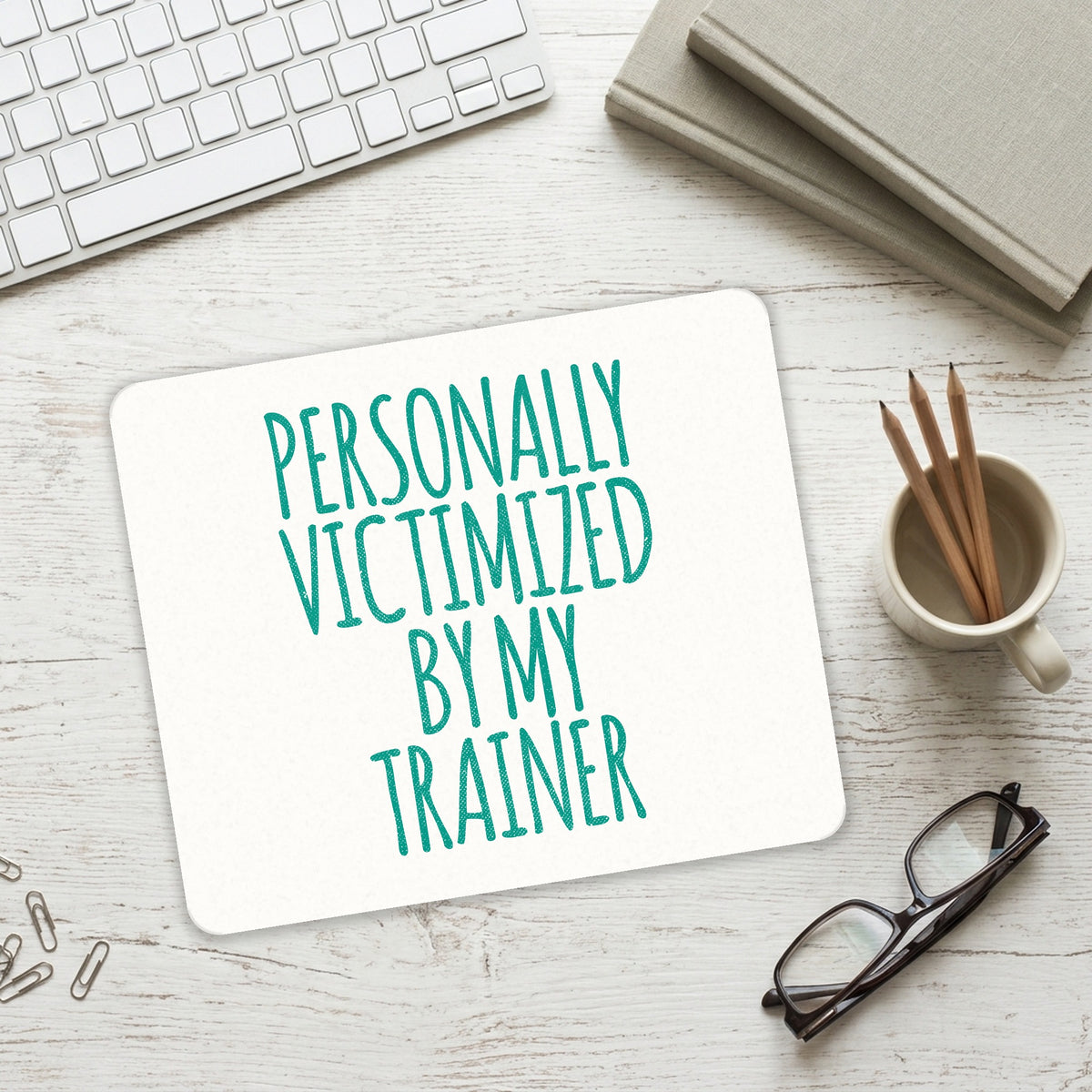 Personally Victimized by My Trainer mouse pad on a desk with a keyboard