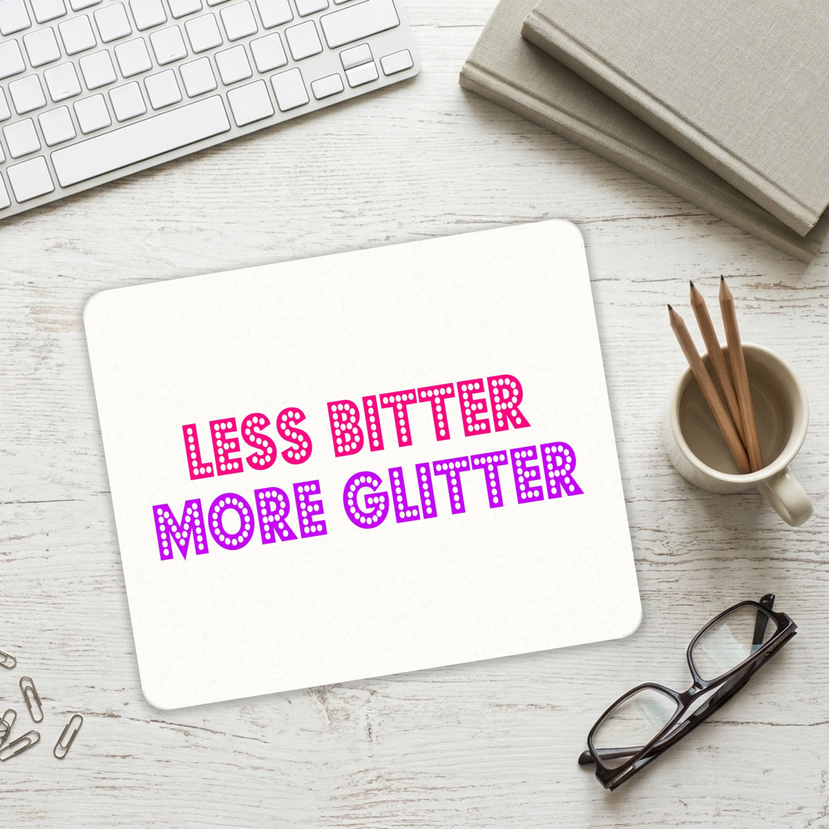 Less Bitter More Glitter mouse pad on a desk with a keyboard