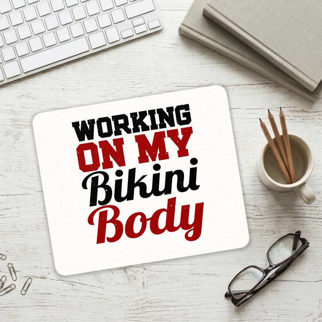 Working On My Bikini Body mouse pad on a desk with a keyboard