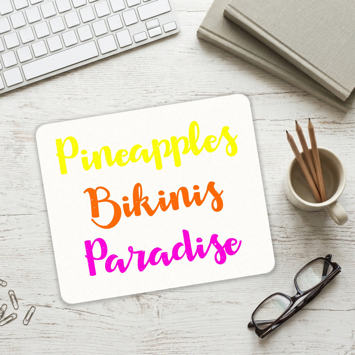 Pineapples Bikinis Paradise mouse pad on a desk with a keyboard
