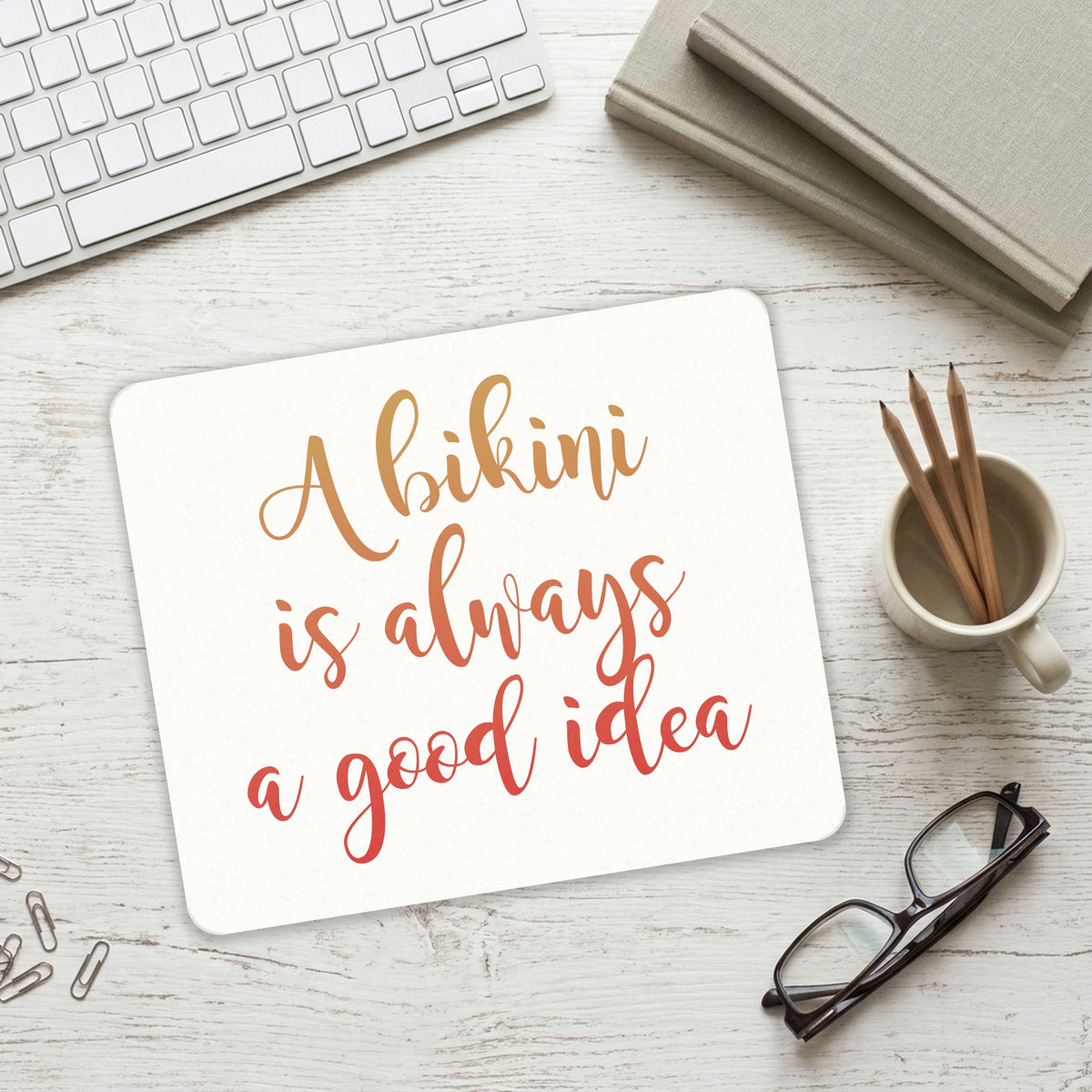 A Bikini is Always a Good Idea mouse pad on a desk with a keyboard