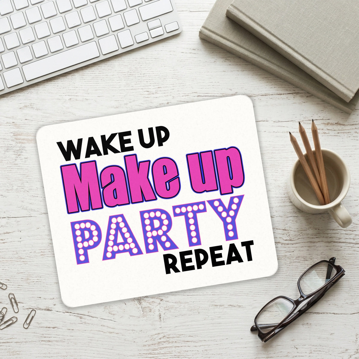 Wake Up Make Up Party Repeat mouse pad on a desk with a keyboard
