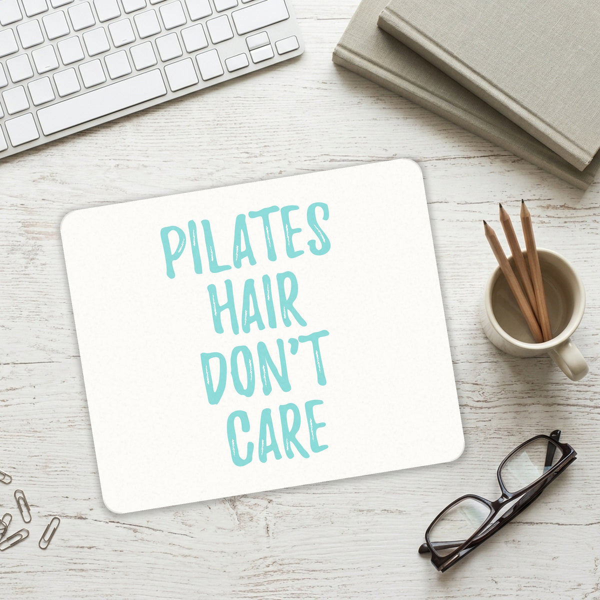 Pilates Hair Don't Care mouse pad on a desk with a keyboard