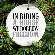 DistinctInk® Hanging Ceramic Christmas Tree Ornament with Gold String - Great Gift / Present - 2 3/4 inch Diameter - In Riding a Horse, We Borrow Freedom