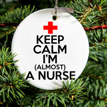 DistinctInk® Hanging Ceramic Christmas Tree Ornament with Gold String - Great Gift / Present - 2 3/4 inch Diameter - Keep Calm I'm Almost a Nurse