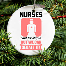 DistinctInk® Hanging Ceramic Christmas Tree Ornament with Gold String - Great Gift / Present - 2 3/4 inch Diameter - Nurses Can't Fix Stupid But Can Sedate It